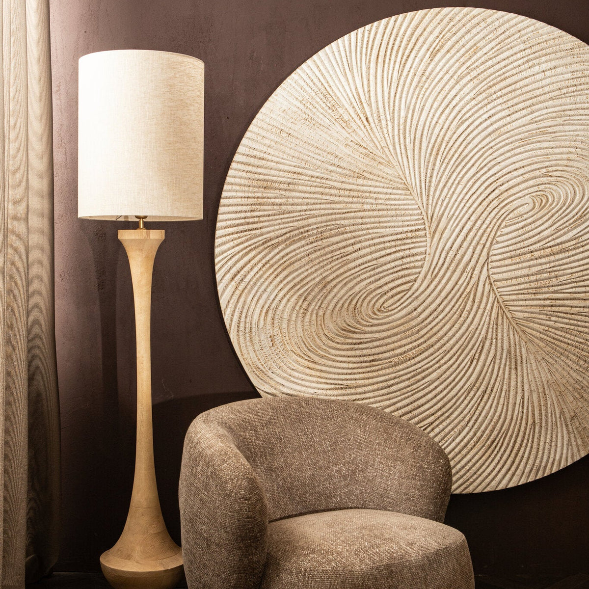 Wandpaneel Wiktor Rond Wit Ø180cm van PTMD aan een donkere muur naast een vloerlamp en fauteuil