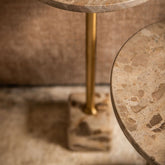 Detail van de Ebe bijzettafel van PTMD, marmeren voet en blad met goudkleurige stang