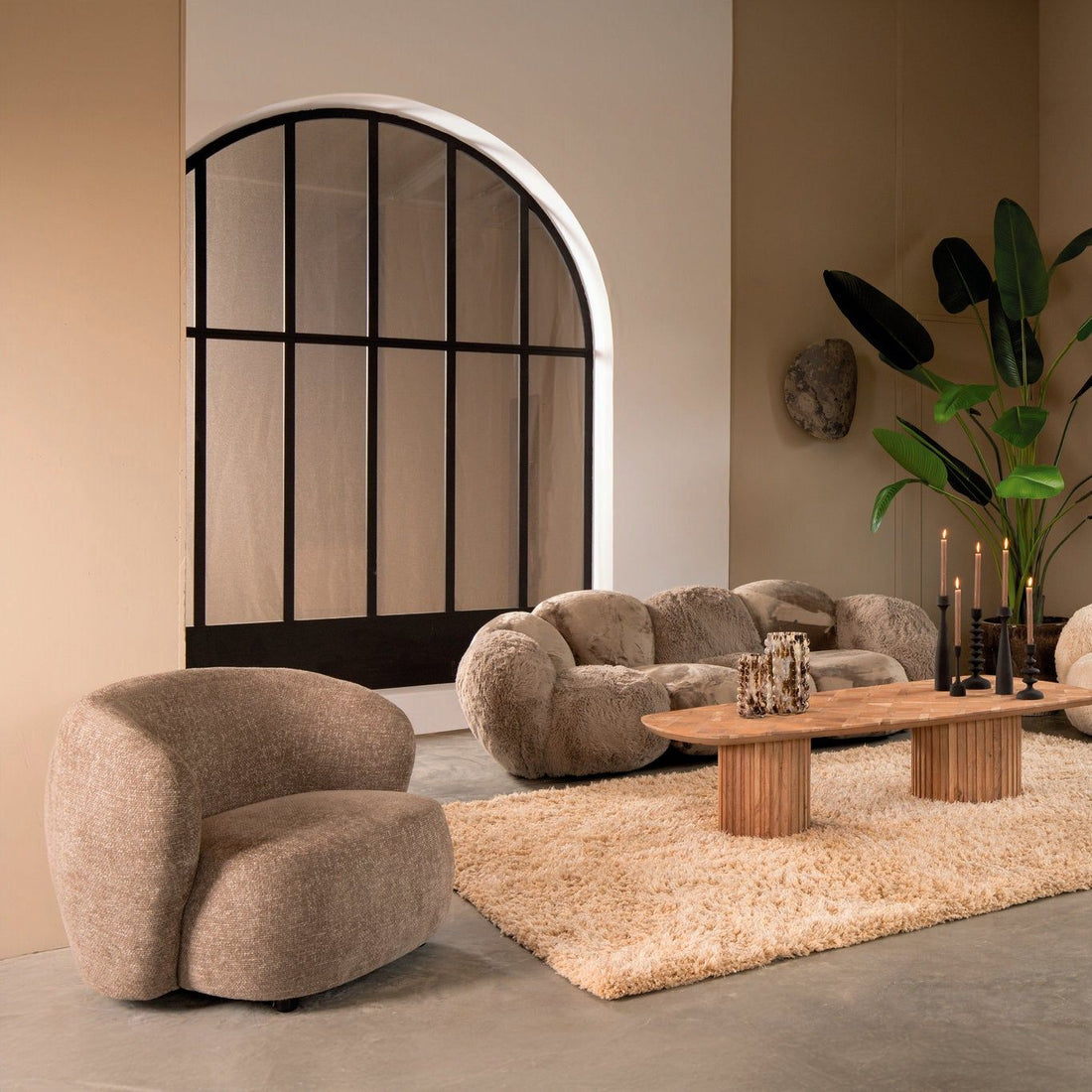 Curvae Sofa Lush Taupe van PTMD in een lichte woonkamer met boogvenster, fauteuil en vloerkleed