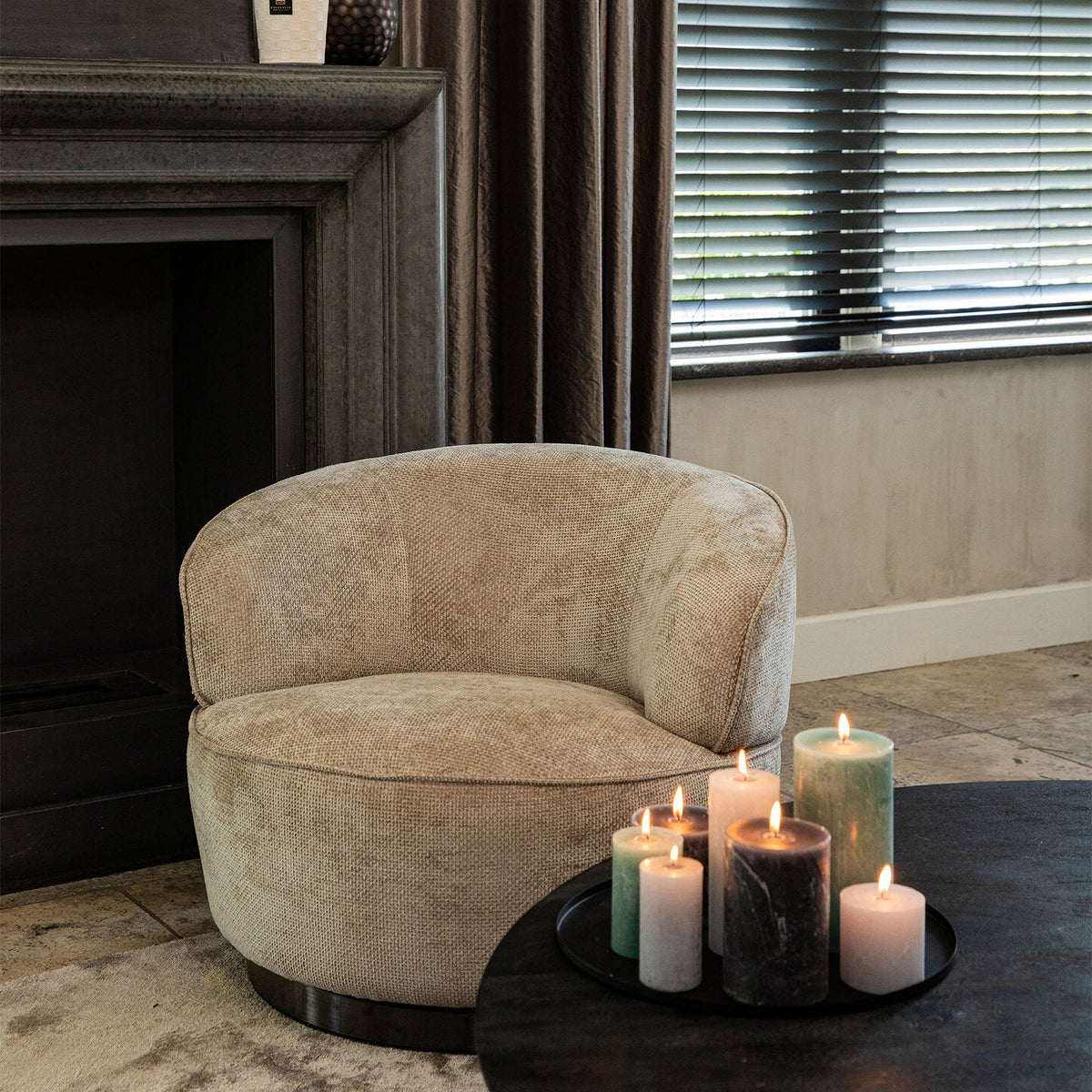 Filou fauteuil beige van PTMD in een sfeervolle woonkamer naast een salontafel met kaarsen