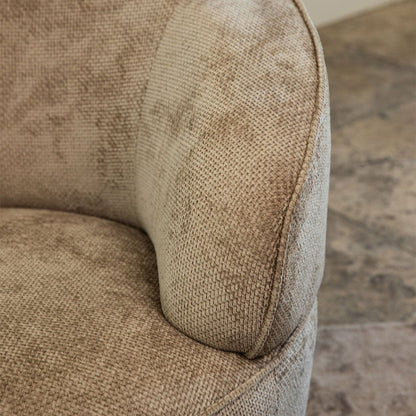 Detail van de zachte beige Eden stof en de ronde armleuning van de Filou fauteuil