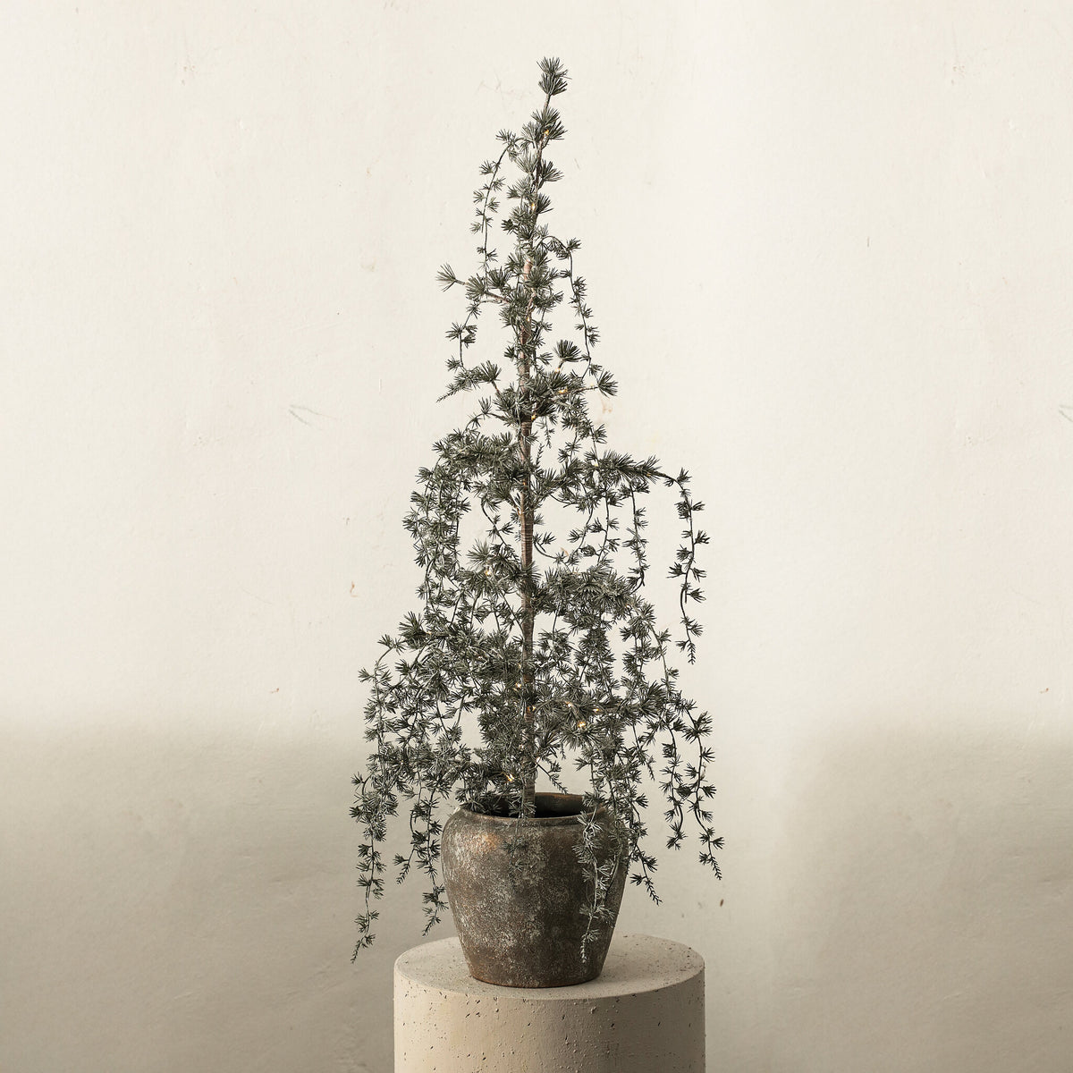 Florine Kerstboom LED Met Sneeuw Medium van PTMD, besneeuwde LED kerstboom in een pot in een lichte woonkamer
