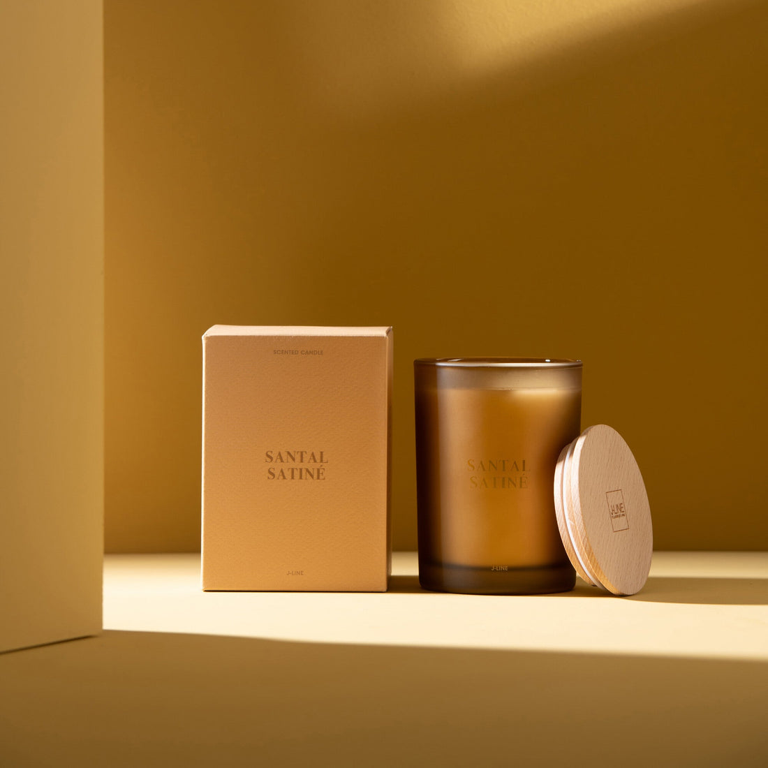 Geurkaars Accords Essentiels Santal Satiné 38 Uur van J-Line met bijpassende doos in een sfeervolle gele setting
