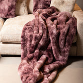 Linde Plaid Burgundy Fluweel 150x200cm van PTMD, burgundy plaid gedrapeerd over een bank met bijpassende kussens