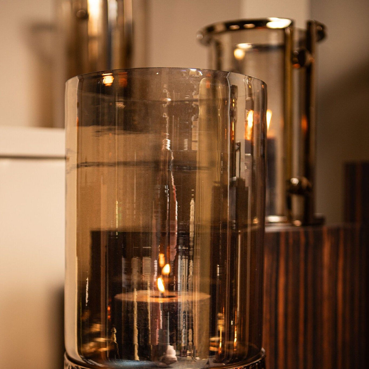 Rezy Windlicht op Voet Bruin Goud Small van PTMD, close up van het amber glas met brandende kaars