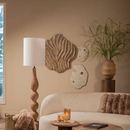 Woonkamer met Abbie wandpanelen van PTMD boven een lichte bank, met staande lamp en salontafels