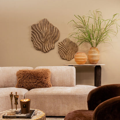 Abbie wandpanelen van PTMD boven een beige bank met een bruine fauteuil op de voorgrond