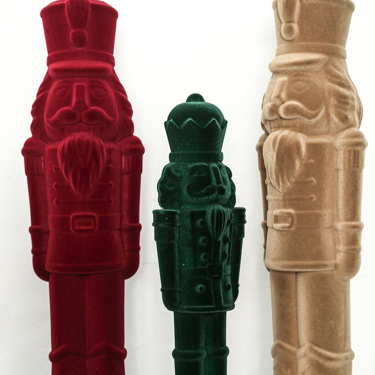 Yule Notenkraker Beige Large van PTMD, fluwelen notenkrakers in bordeaux, groen en beige naast elkaar